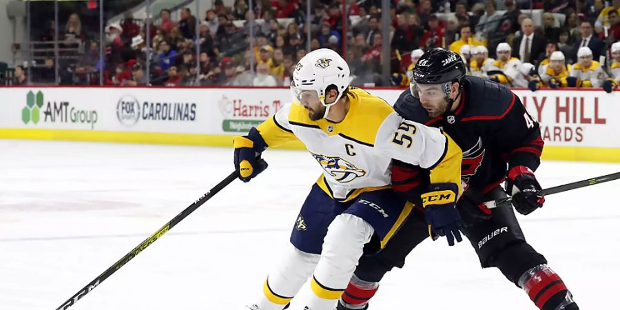 Roman Josi (links) setzt sich gegen Jordan Martinook von den Carolina Hurricanes durch