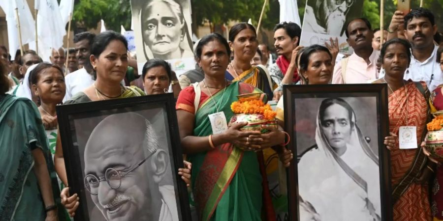 Teilnehmer des Friedensmarsches mit einem Gandhi-Porträt