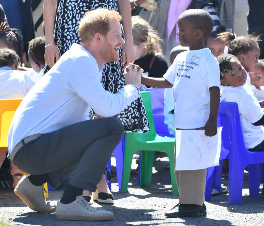 Prinz Harry spricht mit einem Kind im Nyanga-Township in Kapstadt. Der 38-Jährige fühlt sich mit dem Land verbunden.