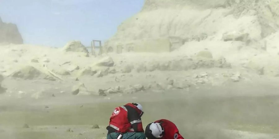 Rettungskräfte auf der Vulkaninsel White Island. Aus der Touristeninsel ist nach dem Ausbruch von Neuseelands gefährlichstem Vulkan eine Todeszone geworden. Foto: -/XinHua/dpa