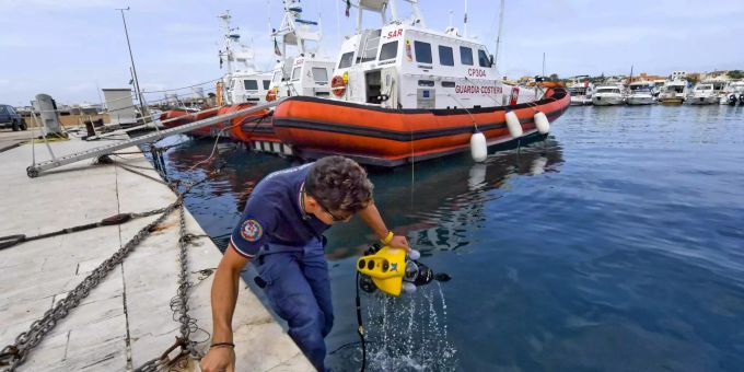 Die Mitglieder der italienischen Küstenwache bereiten den Unterwasserroboter und die Ausrüstung für die Suche nach Migranten und ihrem Schiff vor, das vor Lampedusa in Lampedusa, Süditalien, gesunken ist. lampedusa