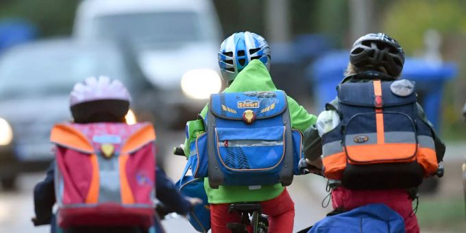 Kinder sind mit dem Fahrrad unterwegs zur Schule (Symbolbild) Kinder Deutsch