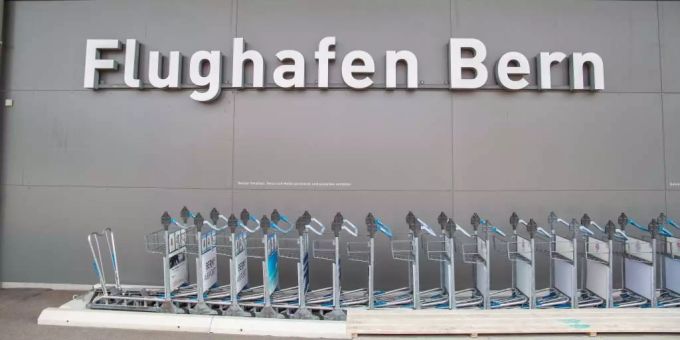 Gepäckwagen vor dem Haupteingang des Flughafens Bern in Belp Flughafen Belp