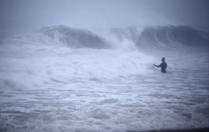 Ein Surfer wagt sich ins Wasser, als die ersten Ausläufer des Tropensturms die Küste von Rhode Island erreichen. Tropical Weather Atlantic