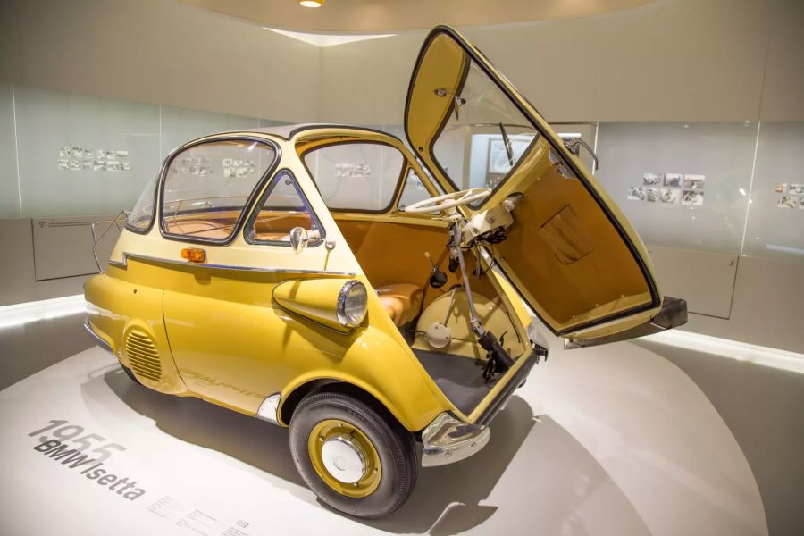 Antithese in Gelb: Der BMW Isetta war ein Motocoupé (oder auch Kabinenroller) fürs bescheidenere Budget und steht wie wenige Autos für die Aufbruchstimmung zur Zeit des Wirtschaftswunders in den 1950er Jahren. Witziges Detail: Zum Einsteigen öffnet man die Fronttür und das Steuerrad schwenkt seitlich nach vorne.