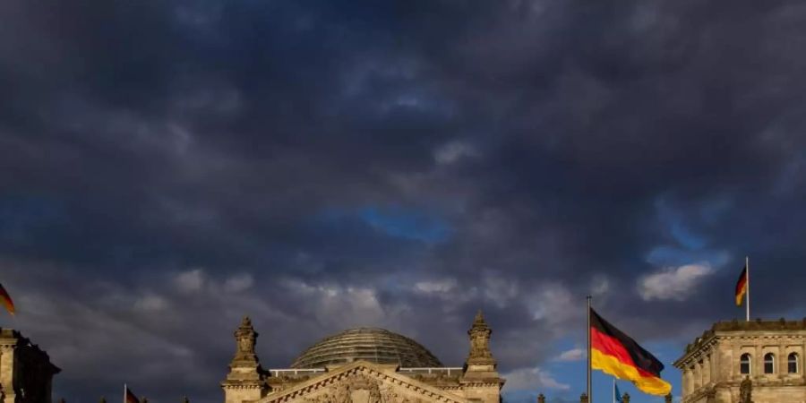 Dunkle Wolken ziehen über das Reichstagsgebäude in Berlin. Foto: picture alliance / Sven Hoppe/dpa