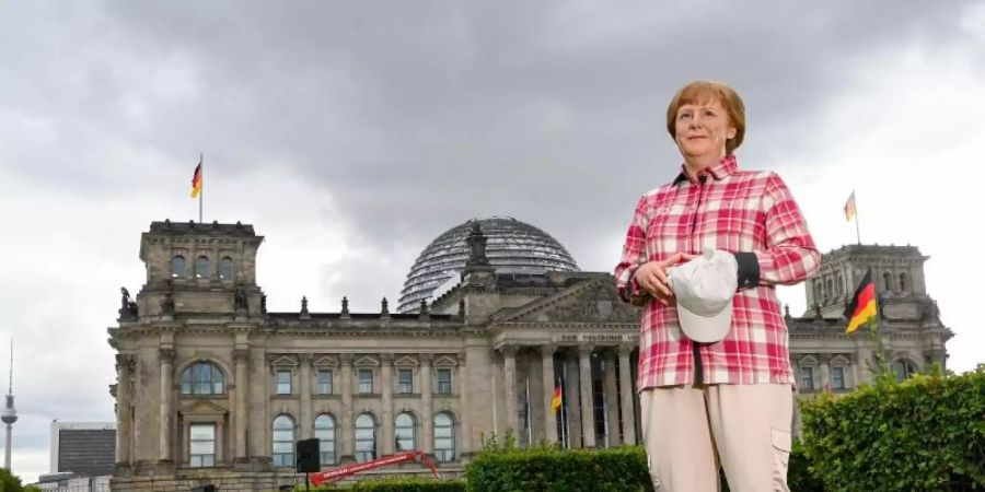 Die Wachsfigur von Bundeskanzlerin Angela Merkel (CDU) vor dem Reichstagsgebäude in Berlin. Foto: Jens Kalaene/dpa-Zentralbild/dpa