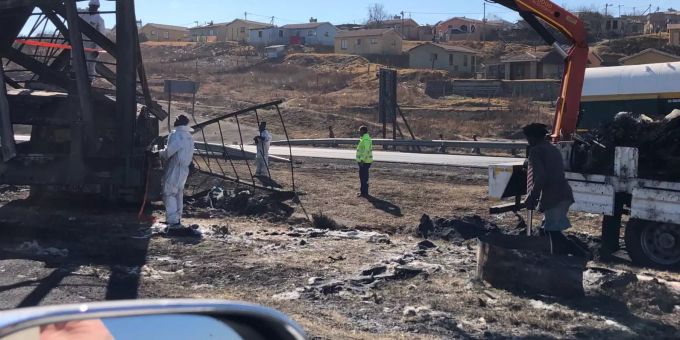 Arbeiter stehen in der Süd-östlichen Provinz Kwa-Zulu Natal an verkohlten Trümmern an einer Mautstelle auf einer Strasse, an der zuvor gewalttätige Demonstranten, die gegen die Haftstrafe von Ex-Präsident Zuma protestierten, mehrere Autos und Lastwagen in Brand gesteckt hatten. Südafrika