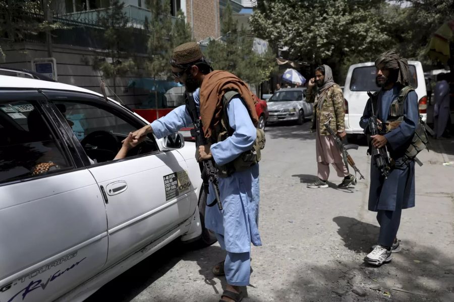 Kämpfer der Taliban kontrollieren an einem Wachposten in Kabul am 18. August 2021 Fahrzeuge.