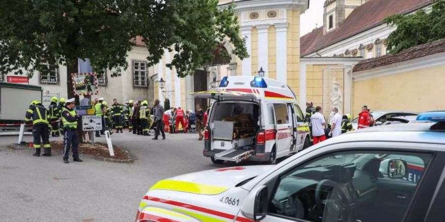 Rettungskräfte arbeiten an einer Unfallstelle auf einem Wochenmarkt, nachdem ein 87-Jähriger Mann in einen Marktstand gefahren ist. Foto: Matthias Lauber/ Laumat.At/APA/dpa