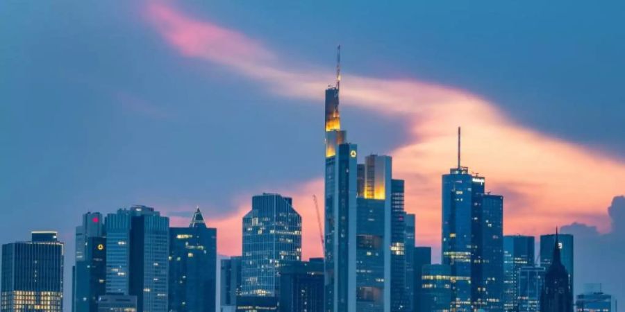 Auf dem Main fährt ein Schiff vor der Skyline der Bankenmetropole. Foto: Boris Roessler/dpa