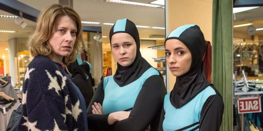 Wanda (Caroline Peters) kauft für ihre Tochter Nina (Chantal Zitzenbacher, M) und deren beste Freundin Maryam (Duygu Arslan) einen Burkini. Foto: Philipp Schönitz/ZDF/Neue Visionen Film/Arte/dpa