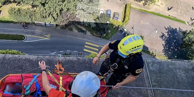 Ungewöhnlicher Rettungseinsatz: Ein verletzter Mann ist am Sonntag in Genf an einem Seil mit einem Helikopter aus einem hohen Gebäude geborgen worden. rega