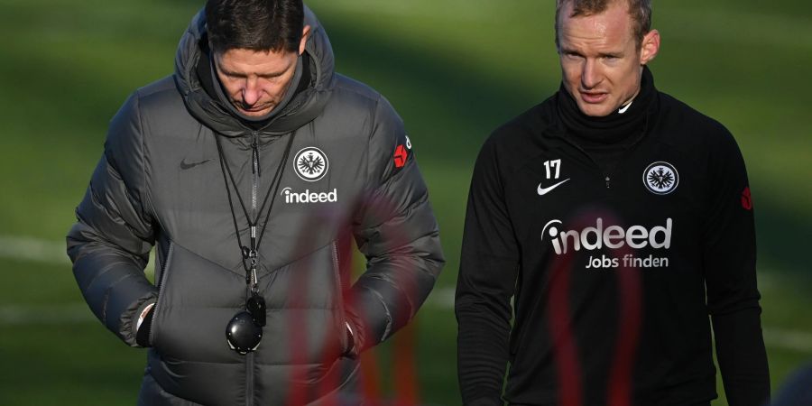 Sebastian Rode (r) unterhält sich beim Trainingsauftakt mit Eintracht Frankfurts Cheftrainer Oliver Glasner.