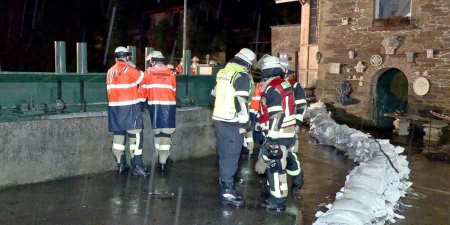 Einsatzkräfte der Feuerwehr in Solingen bei einer durch Dauerregen überfluteten Strasse im Einsatz.