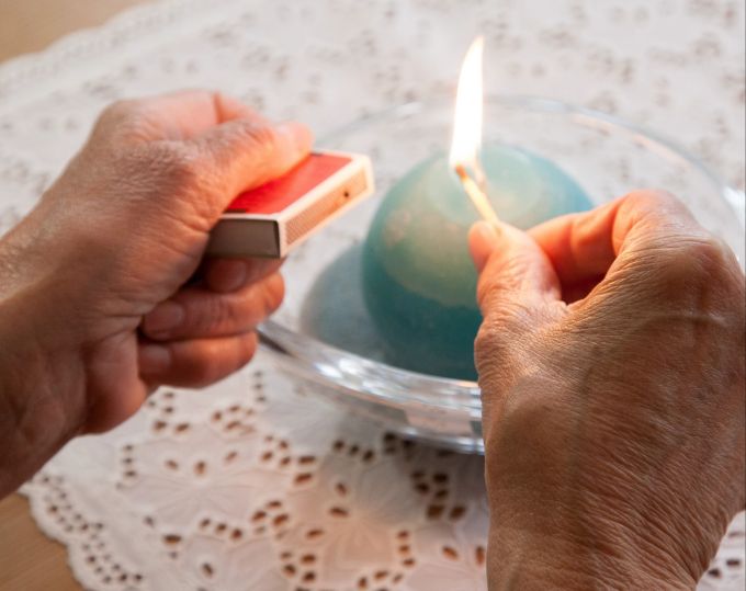 Wenn eine kleine Flamme zum grossen Risiko wird: Gerade wenn eine Kerze zu nah an eine Vase mit Blumenstrauss gerückt wird, wird es schnell brenzlig. Hände Flamme Kerze Streichhölzer