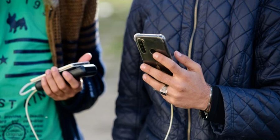 Junge Männer mit Smartphones.