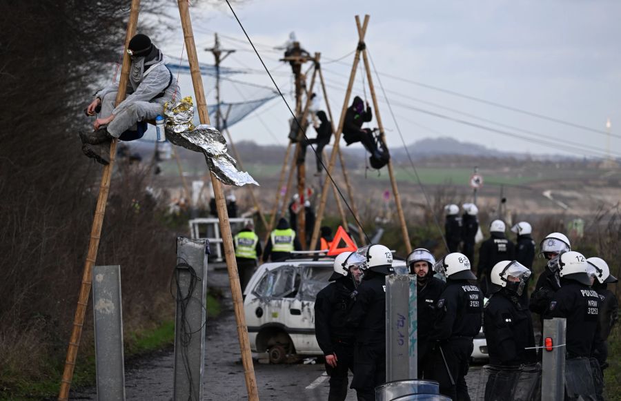 Demonstranten sitzten während der Räumung des Dorfes Lützerath auf Konstruktionen aus Balken. Der Energiekonzern RWE will die unter Lützerath liegende Kohle abbaggern - dafür soll der Weiler auf dem Gebiet der Stadt Erkelenz am Braunkohletagebau Garzweiler II abgerissen werden.