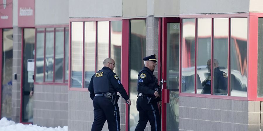 Polizisten gehen in Des Moines, Iowa, in das Gebäude von Starts Right Here. Foto: Charlie Neibergall/AP/dpa