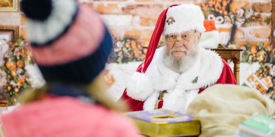 Der Weihnachtsmann Willi Dahmen spricht in seinem Büro in Uelzen mit einem Kind. Eltern betreiben grossen Aufwand, um ihre Kinder von der Existenz eines Weihnachtsmanns oder Christkinds zu überzeugen. Bis zu einem gewissen Alter mit Erfolg.