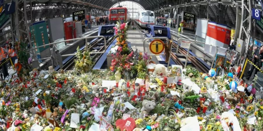 Blumen, Kuscheltiere und Beileidsbekundungen im Frankfurter Bahnhof