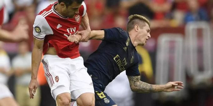 Real-Spieler Toni Kroos (r) wird von Arsenals Sokratis gefoult. Foto: Nick Wass/AP Real-Spieler Toni Kroos (r) wird von Arsenals Sokratis gefoult. Foto: Nick Wass/AP