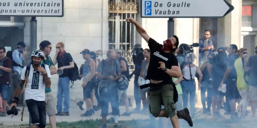 Ein Mann wirft einen Stein bei Protesten in Bayonne