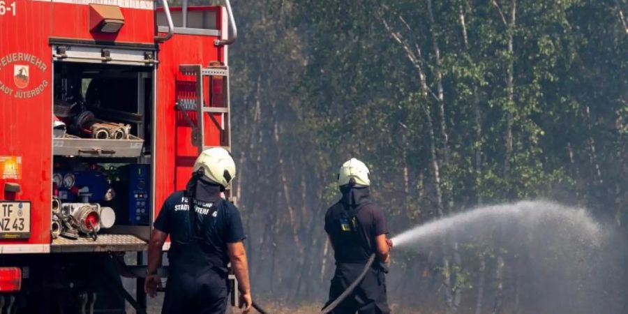 Feuerwehrmänner löschen auf dem früheren Truppenübungsplatz bei Jüterbog. Foto: Monika Skolimowska