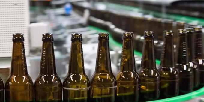 Gewaschene Bierflaschen laufen durch die Produktion einer Brauerei. Foto: Rainer Jensen Gewaschene Bierflaschen laufen durch die Produktion einer Brauerei. Foto: Rainer Jensen