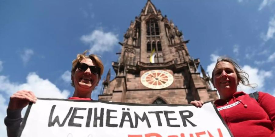 Zwei Frauen der Initiative Maria 2.0 werben vor dem Freiburger Münster für «Weiheämter auch für Frauen». Foto: Patrick Seeger