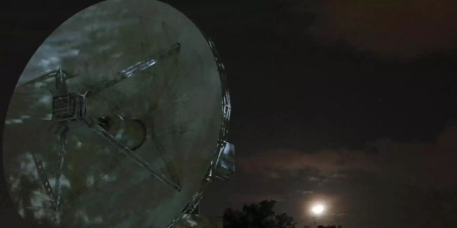 Hinter einer Parabol-Antenne in der Telemetrie-, Ortungs- und Führungsnetzwerkanlage der Indian Space Research Organization ist der Mond zu sehen. Foto: Aijaz Rahi/AP