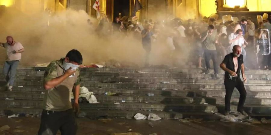 Demonstranten fliehen vor dem georgischen Parlament vor von Polizisten abgefeuertem Tränengas. Foto: Zurab Tsertsvadze/AP