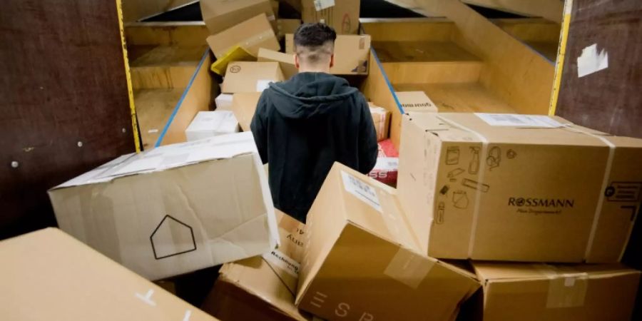 Mitarbeiter sortiert Pakete in Paketzentrum der DHL