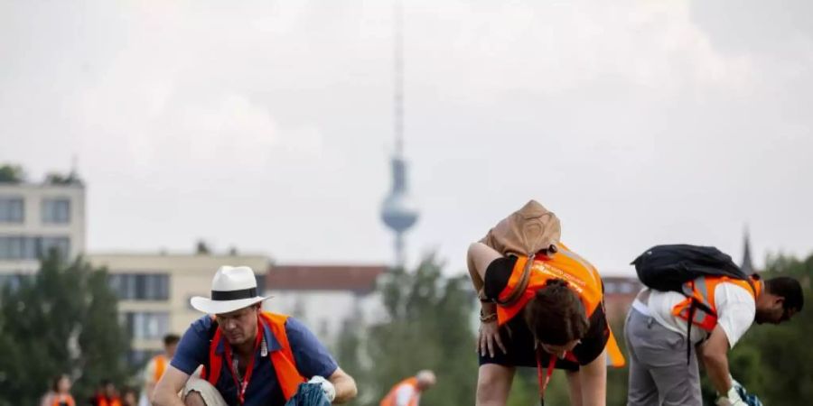 Touristen sammeln bei einer Stadttour im Mauerpark Müll. Ähnliche Müllsammel-Aktionen gab es laut dem Touranbieter «Sandemans New Europe» schon in Edinburgh, Amsterdam, Paris und Barcelona. Foto: Christoph Soeder