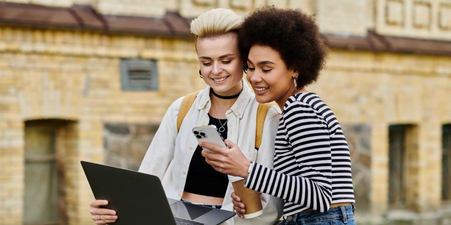 Zwei junge Frauen mit Laptop und Smartphone