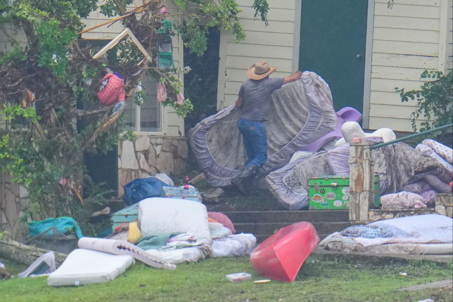 Eine Person entfernt Bettzeug aus den Schlafquartieren im Camp Mystic am Ufer des Guadalupe River, nachdem am Sonntag eine Sturzflut durch die Gegend gefegt war.
