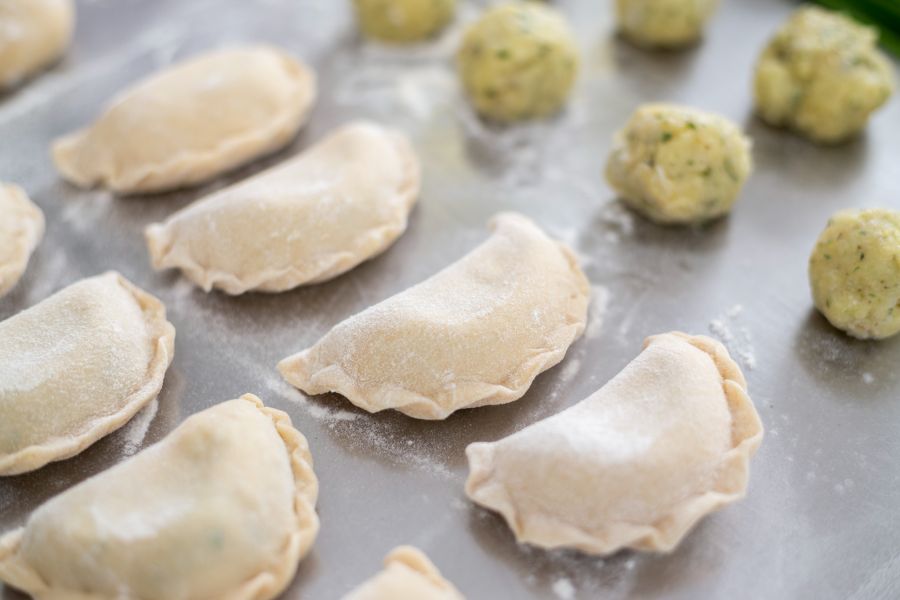 Die Osttiroler Schlipfkrapfen werden mit frischen Kräutern und gekochten Kartoffeln gefüllt und mit würzigem Bergkäse bestreut.