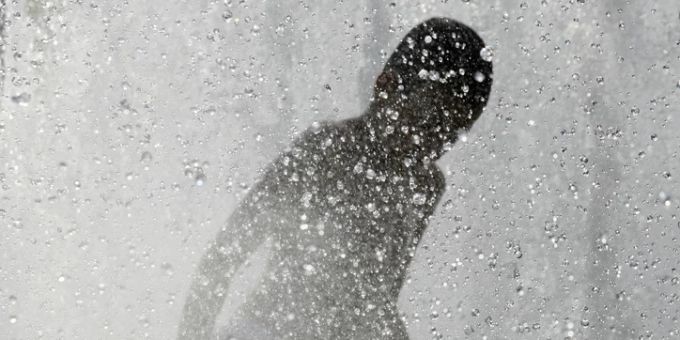 Ein Junge kühlt sich an einem Berliner Wasserspiel ab. Junge kühlt sich ab