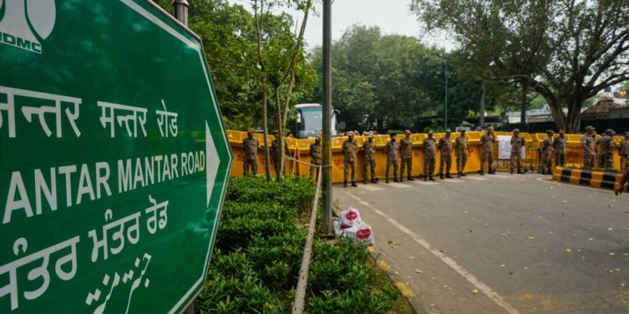 Sicherheitskräfte stehen an den Absperrungen auf einer Straße, die zum Hauptschauplatz der Demonstration führt, während einer Kundgebung in Neu-Delhi, bei der der Rücktritt des Wah...