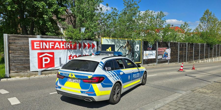 Ein Polizeiauto steht in der Zufahrt zur Tiefgarage eines Baumarkts, wo die Leiche einer Frau im Kofferraum eines Autos gefunden worden ist.