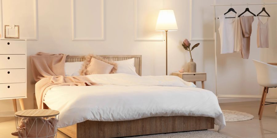 Modernes Schlafzimmer mit Bett, Lampe und Kommode