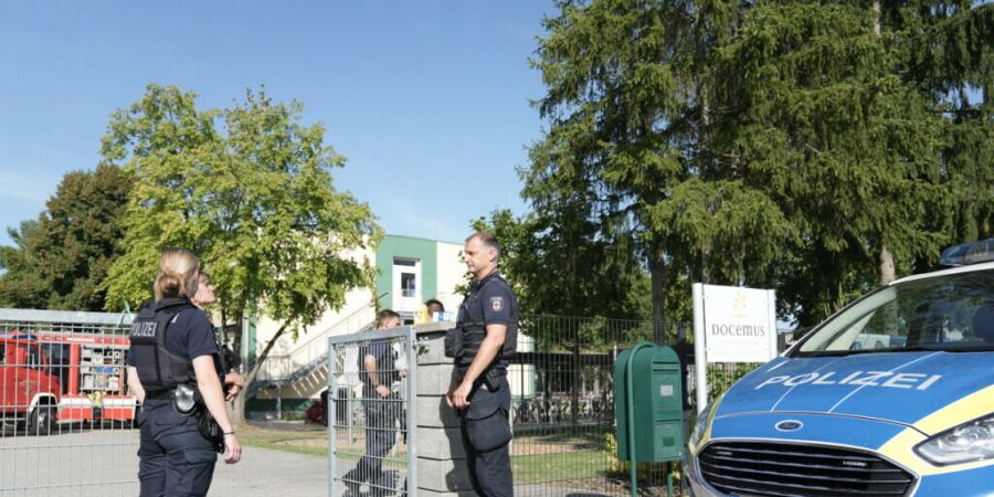 Polizisten stehen vor der Schule in Gosen-Neu Zittau. Foto: Manuel Genolet/dpa