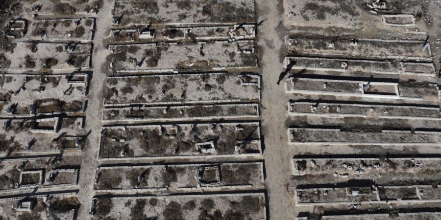 ARCHIV - Eine Luftaufnahme zeigt ein Massengrab in Syrien, in dem Menschen begraben sind, die bei einem Chemiewaffenangriff durch Sarin getötet wurden. Foto: Hussein Malla/AP/dpa/Archi...