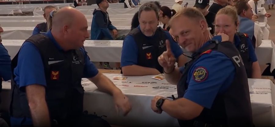 Nach dem Schnupf winkt ein Polizist in die Kamera.