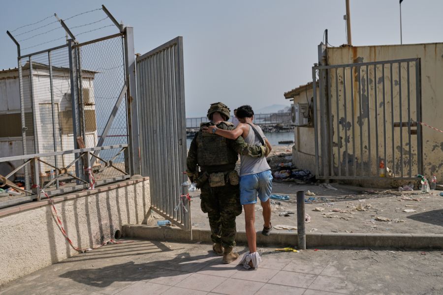 Ein spanischer Soldat führt einen jungen Migranten an einem Tor nahe der Küste von Ceuta ab.