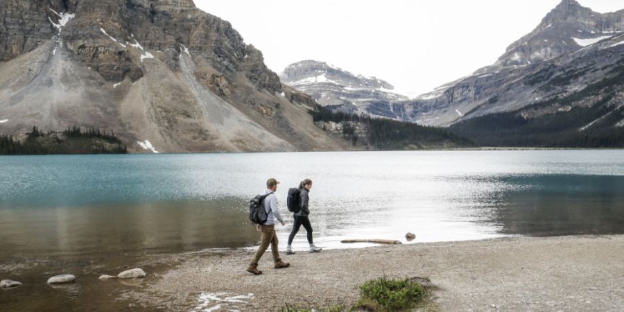 ARCHIV - Touristen spazieren um den Bow Lake in der Nähe der Bow Glacier Falls (im Hintergrund) in Alberta. Foto: Jeff Mcintosh/Canadian Press via ZUMA Press/dpa/Symbolbild - ACHTUNG: ...