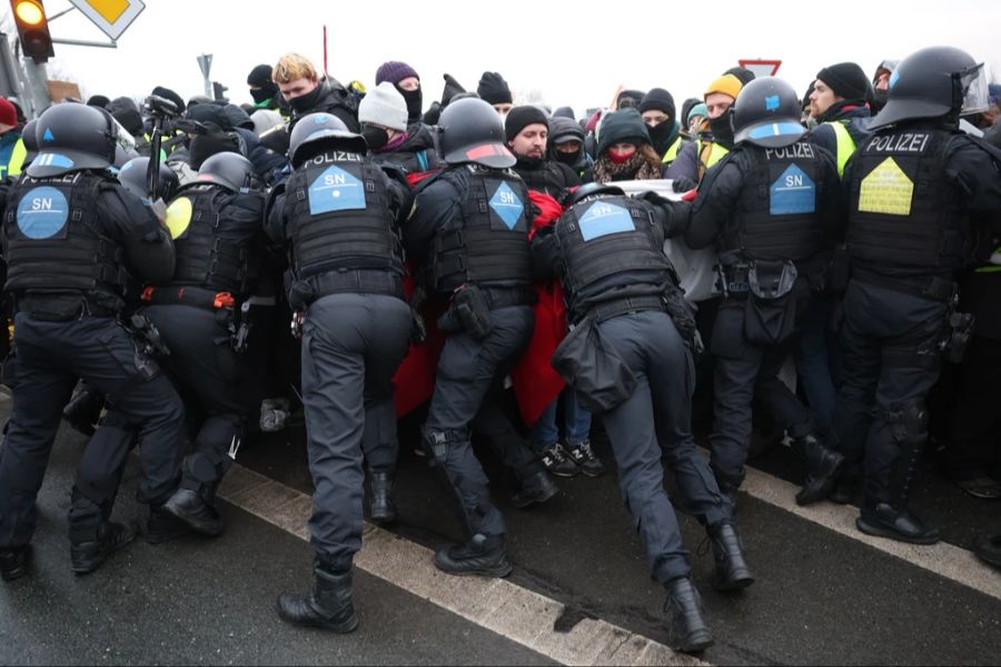 Die Polizei drängt Demonstranten zurück.