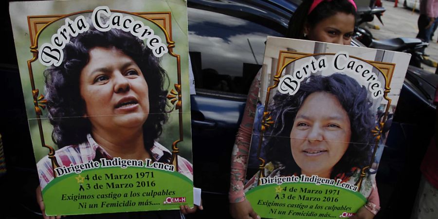 ARCHIV - Zwei Frauen halten bei einem Protest vor dem Sitz der Staatsanwaltschaft Plakaten mit dem Bild der honduranischen Umweltschützerin Berta Caceres. Foto: Fernando Antonio/AP/dpa