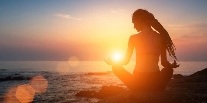 Nach einer Beziehung wieder zu sich selbst finden ist wichtig. Meditation kann dabei genauso helfen, wie eine Solo-Reise. Oder Sie kombinieren es, für den maximalen Effekt. Frau Yoga Sonnenuntergang
