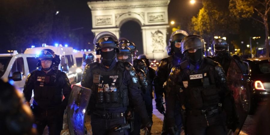 Polizisten patrouillieren vor dem Arc de Triomphe auf der Pariser Champs Élysées. Foto: Christophe Ena/AP